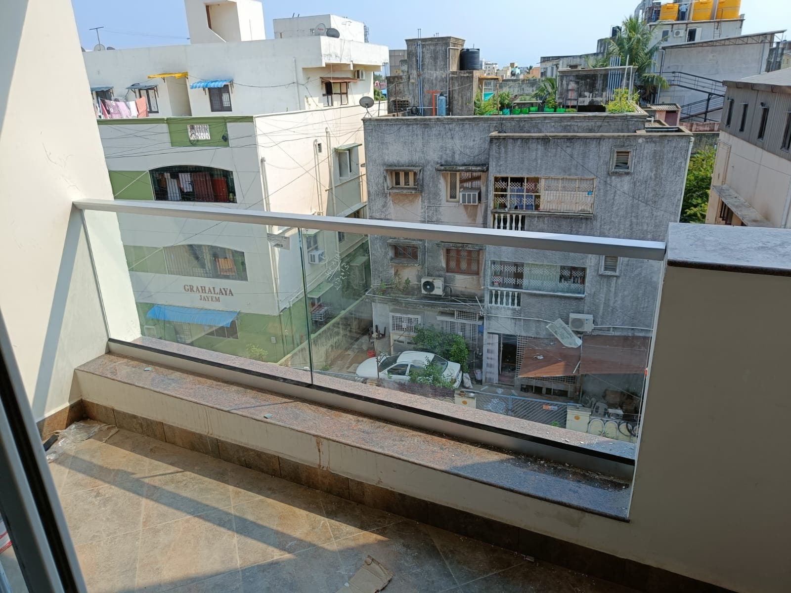 Glass railing on a balcony overlooking neighbouring buildings